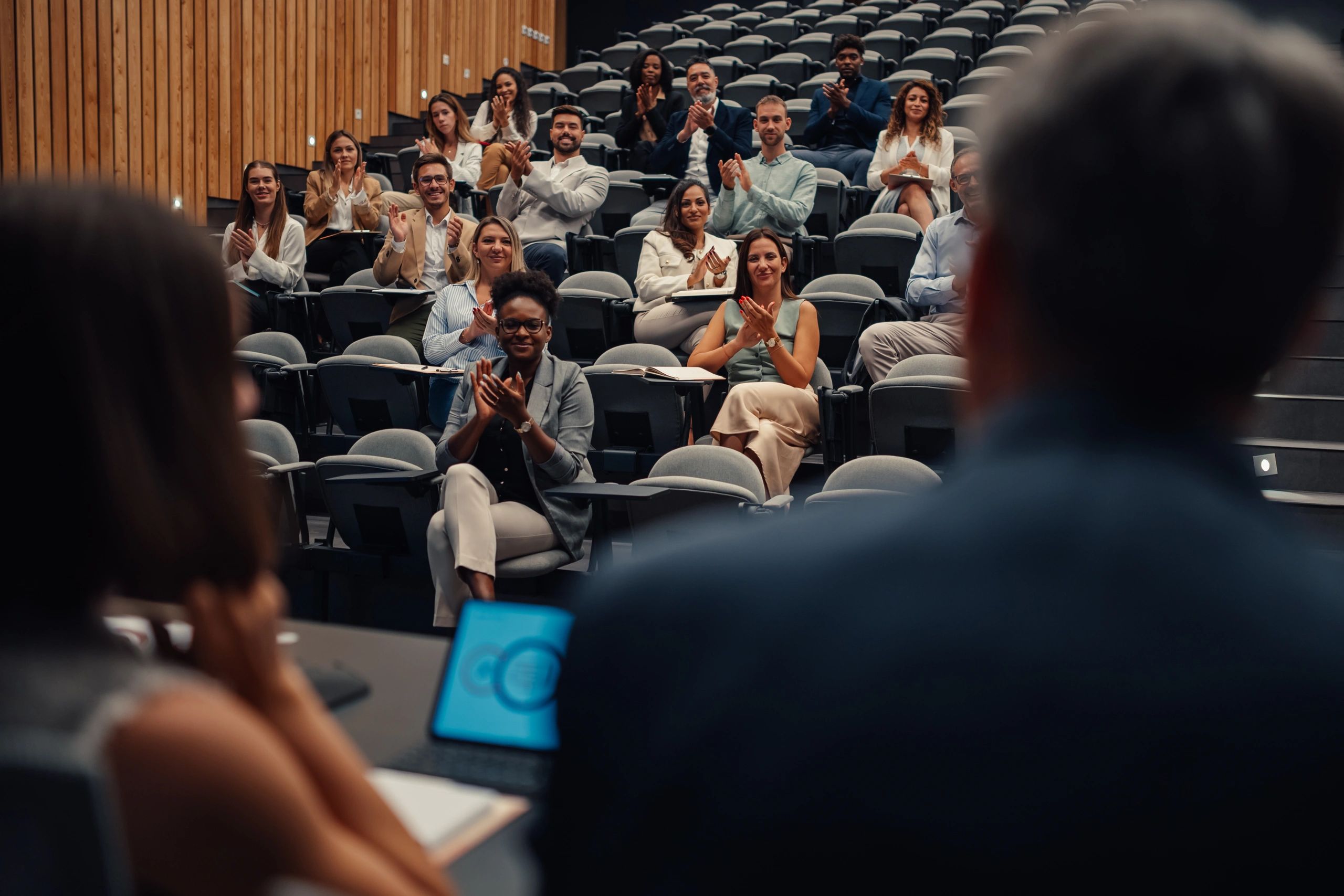 Audience at a diversity conference applauding a presentation